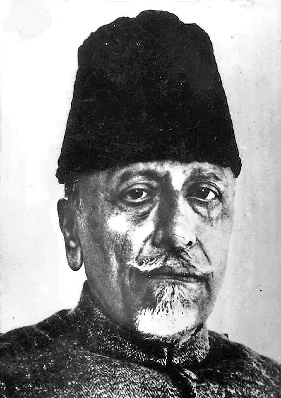 Black-and-white photographic portrait of Maulana Abul Kalam Azad wearing his characteristic tall karakul cap, looking towards the camera.